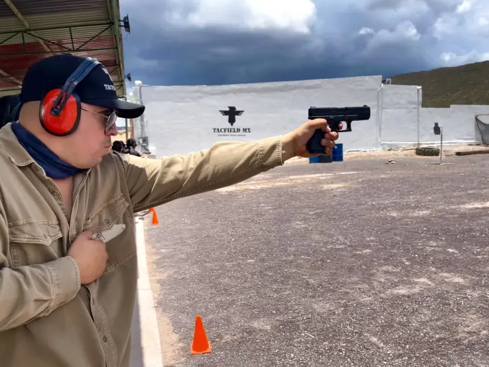 Alumno disparando pistola en la línea de tiro