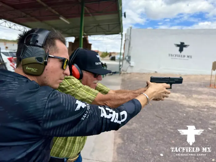 Instructor corrigiendo la postura de tiro con pistola
