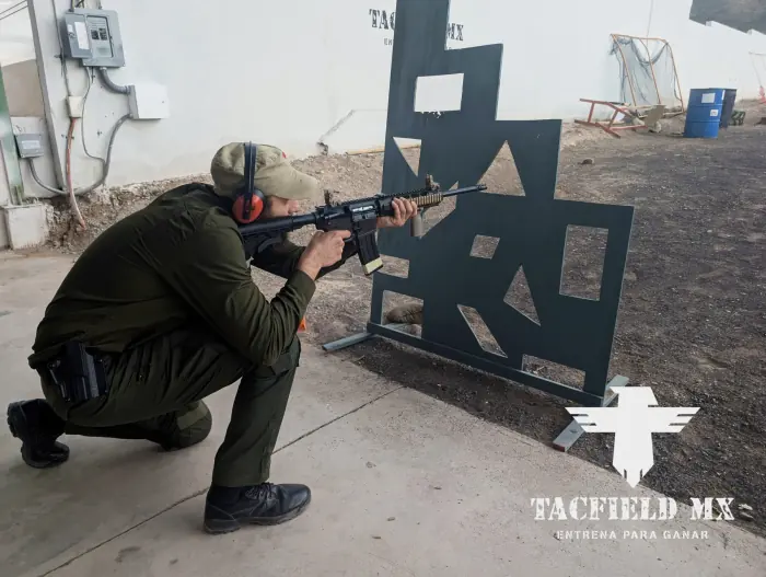 Disparo de rodilla con rifle detrás de cobertura